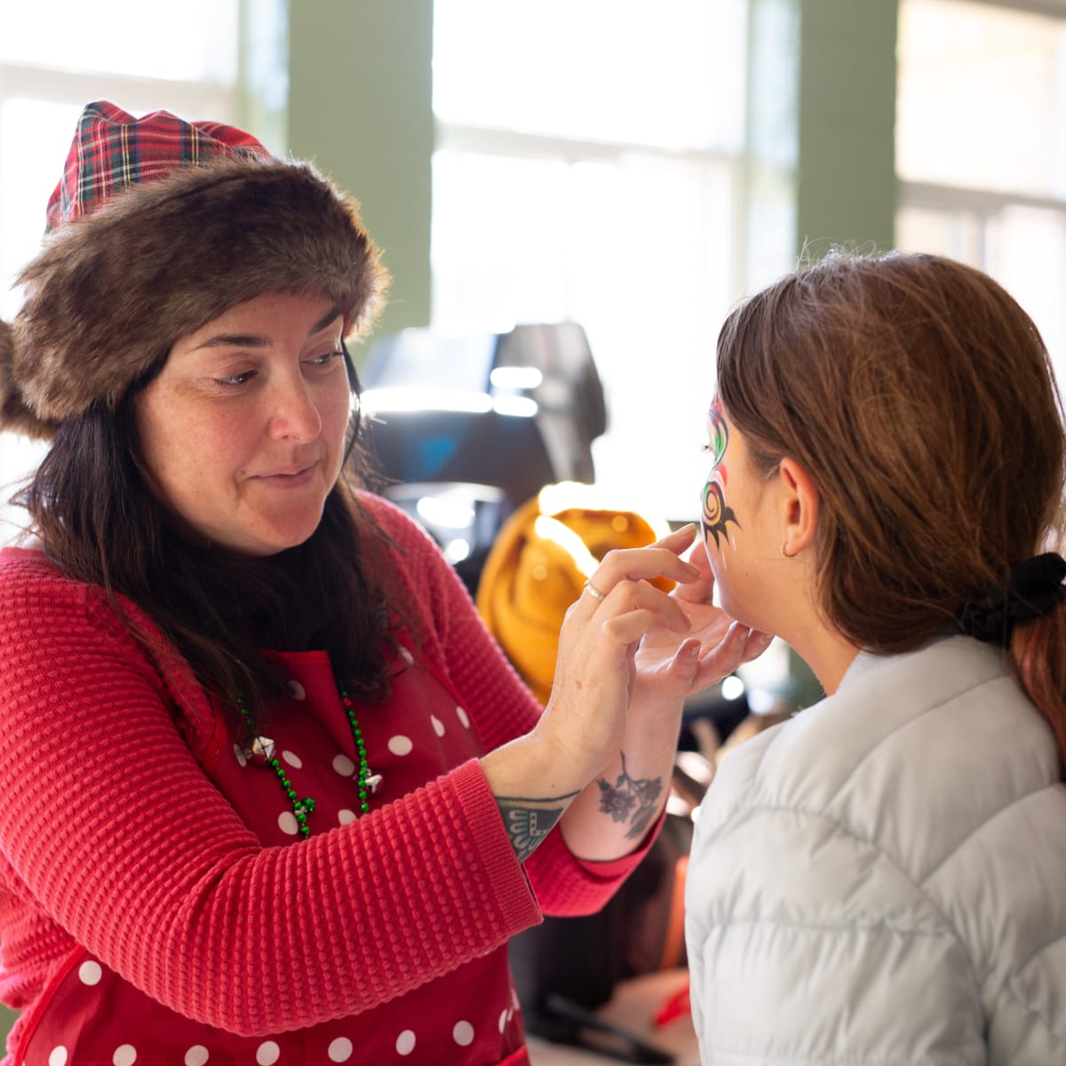 Prévost Christmas Market - A woman putting make-up on a child