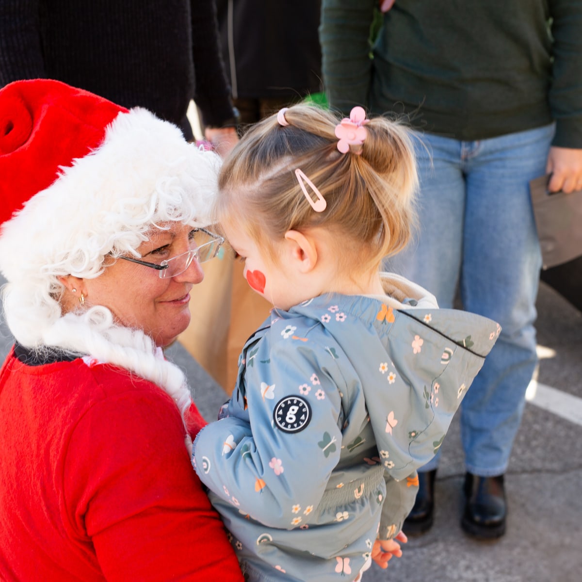 Prévost Christmas Market - A woman dressed as Mother Christmas is holding a child in her arms.