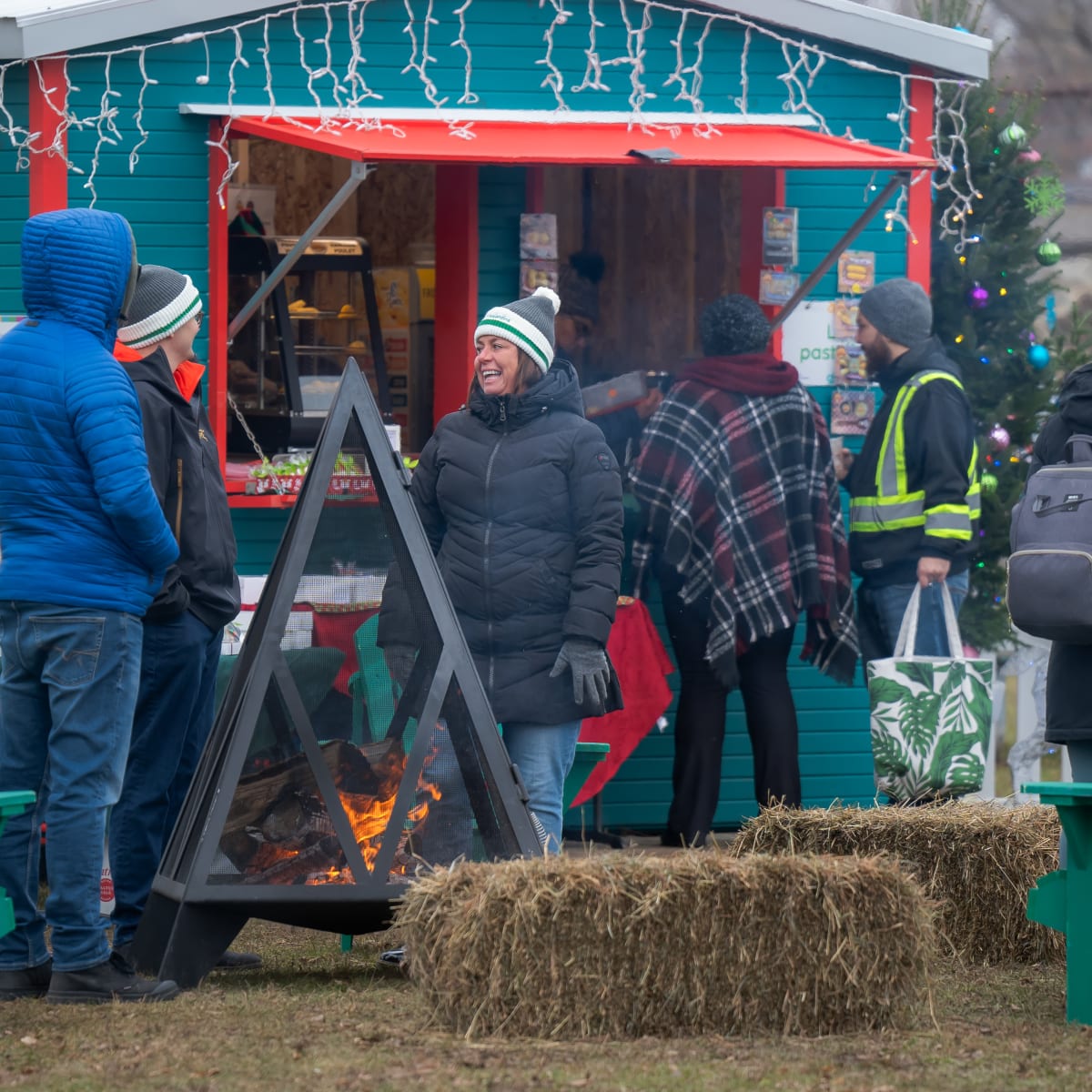People chatting and warming up by a campfire.