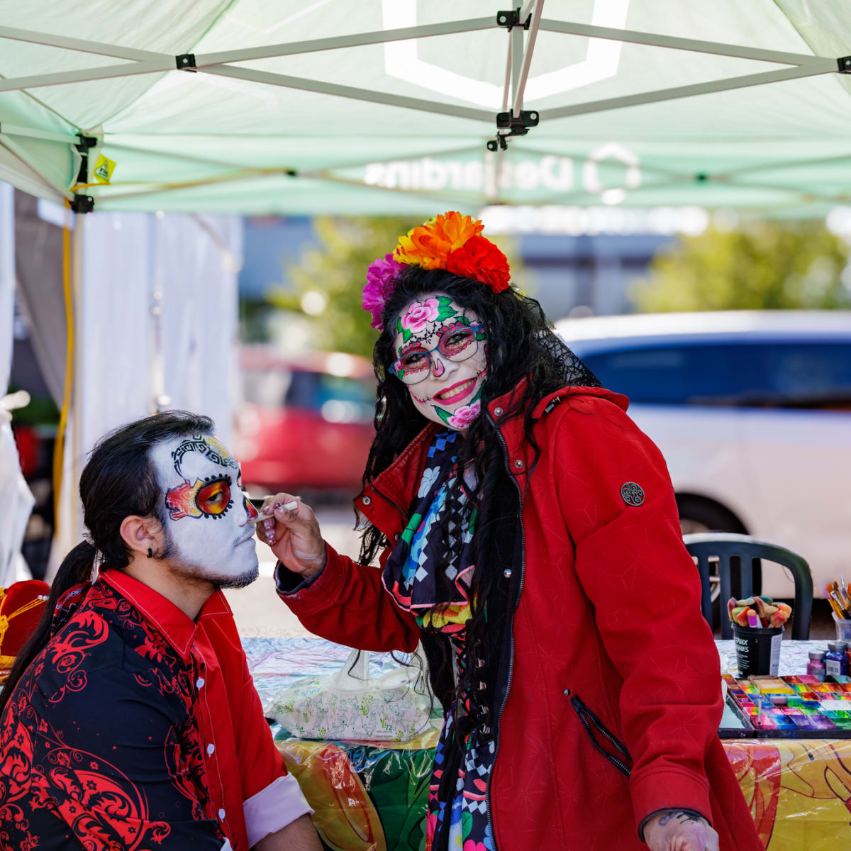 A person gets his face painted at the Mirabel Halloween Market.