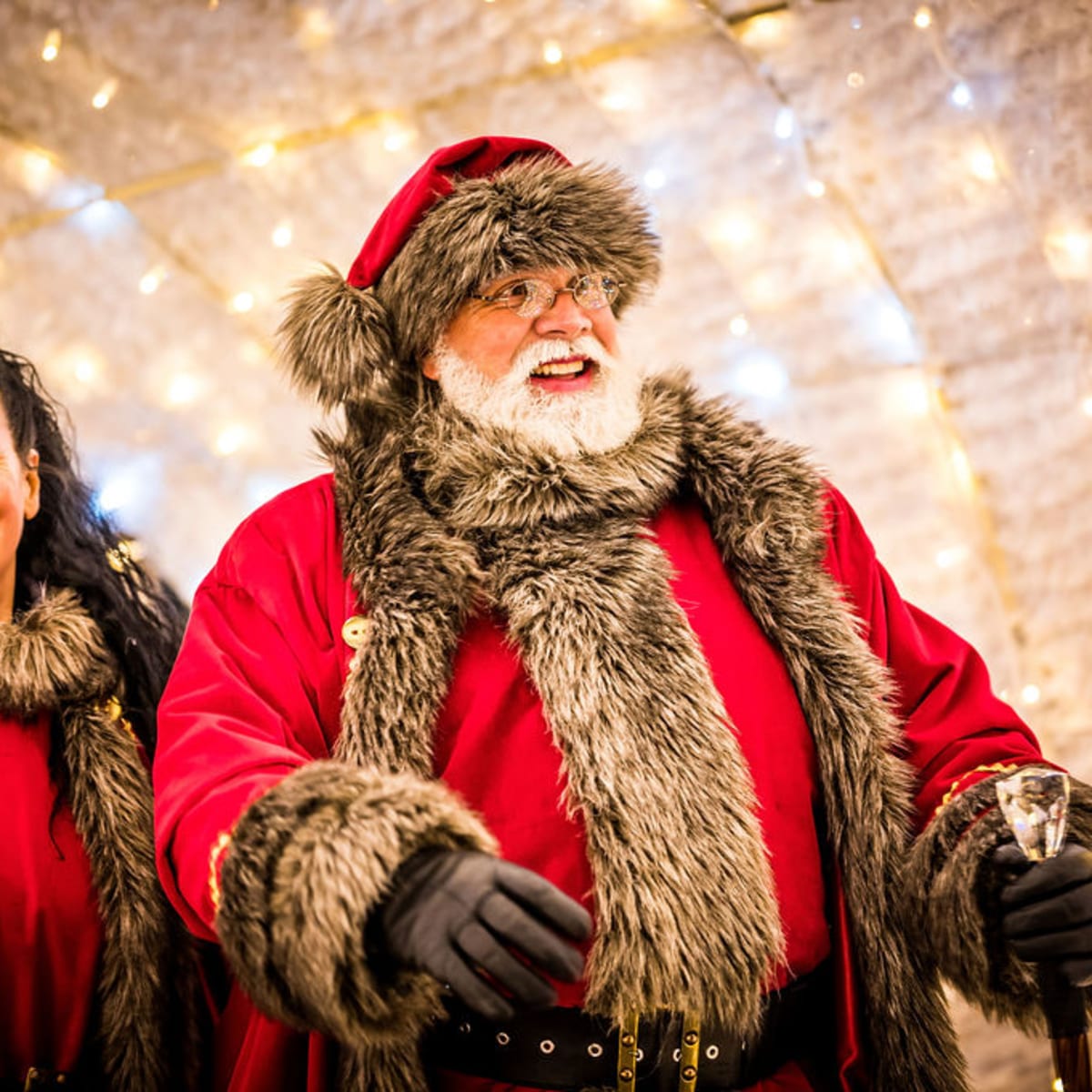 Santa Claus walking through an illuminated passage.