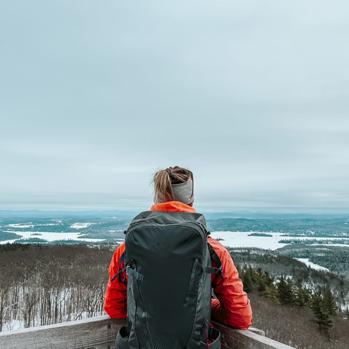 Discover Outaouais and its many areas with these must-sees! - Hiker admiring the view from a mountaintop in winter