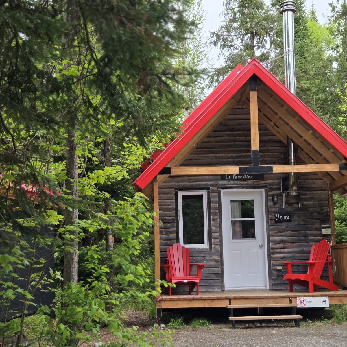 Micro-Chalets des Appalaches - Small cabin with two red chairs on the deck