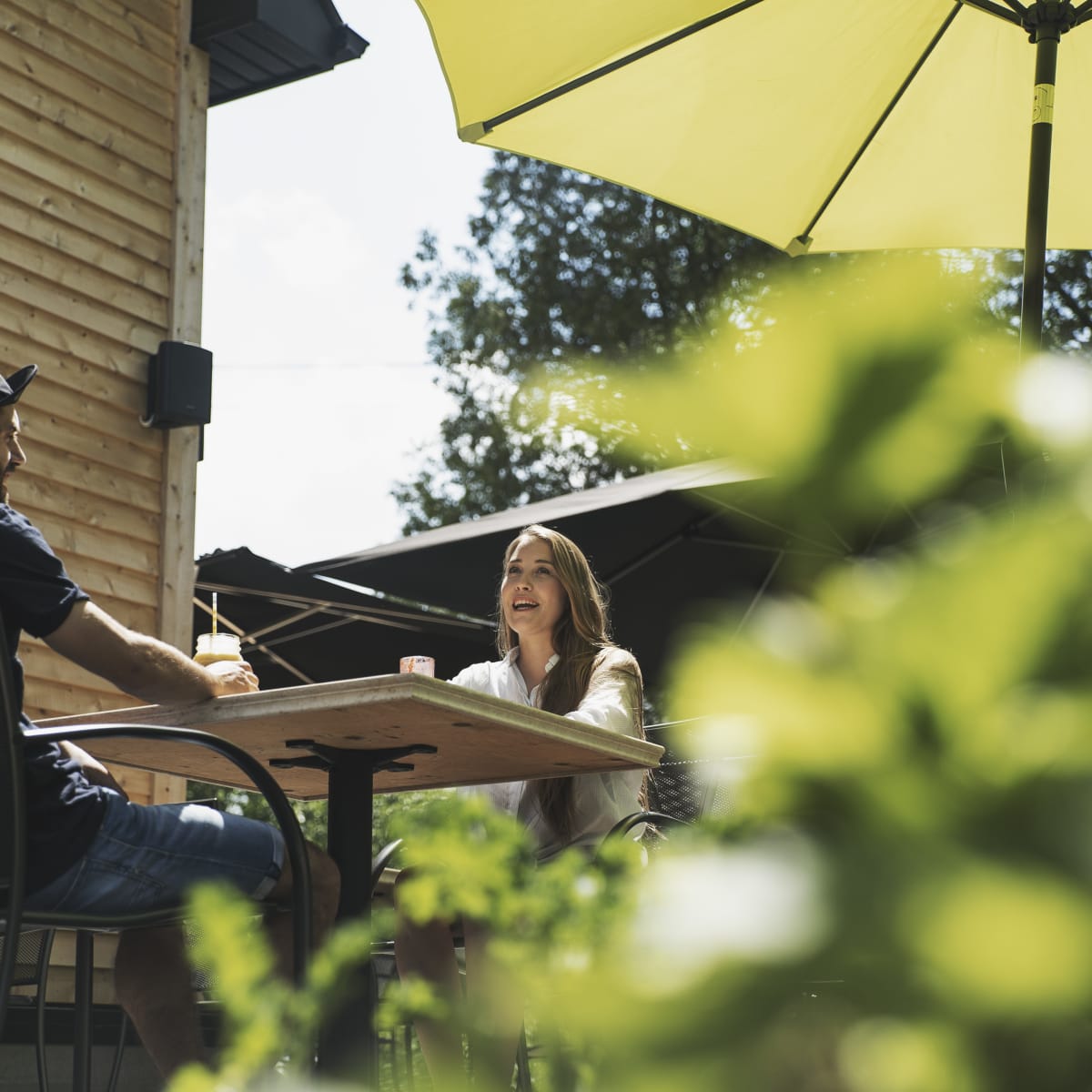 Municipalité d'Orford - A couple sitting at a table on an outdoor terrace