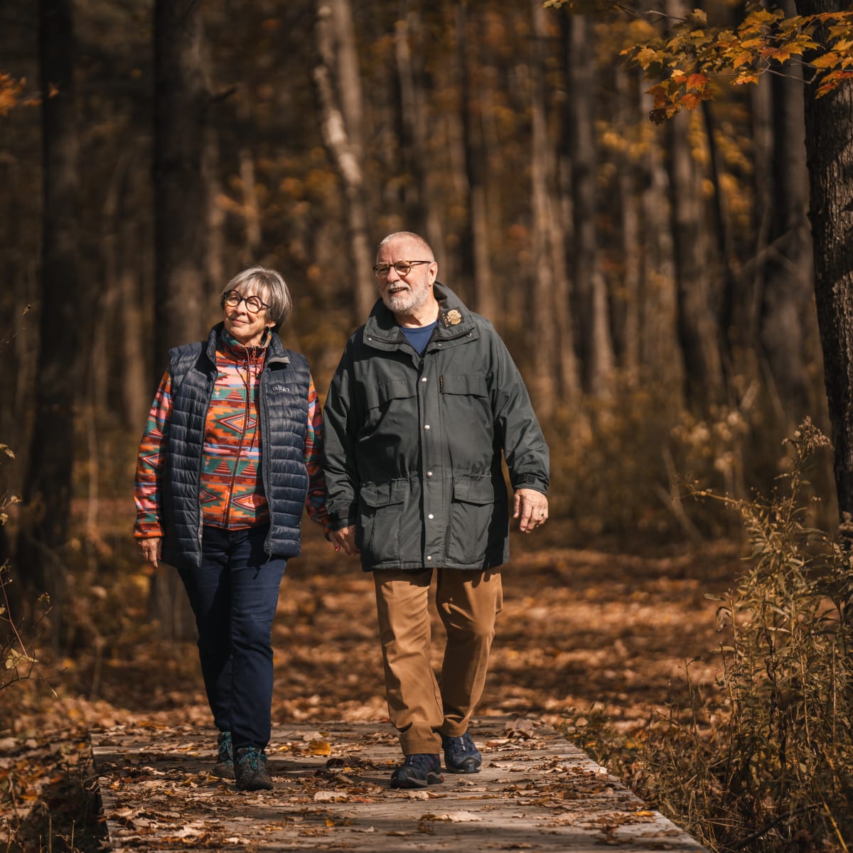 Municipalité d'Orford - A couple walking on a trail in an autumn forest