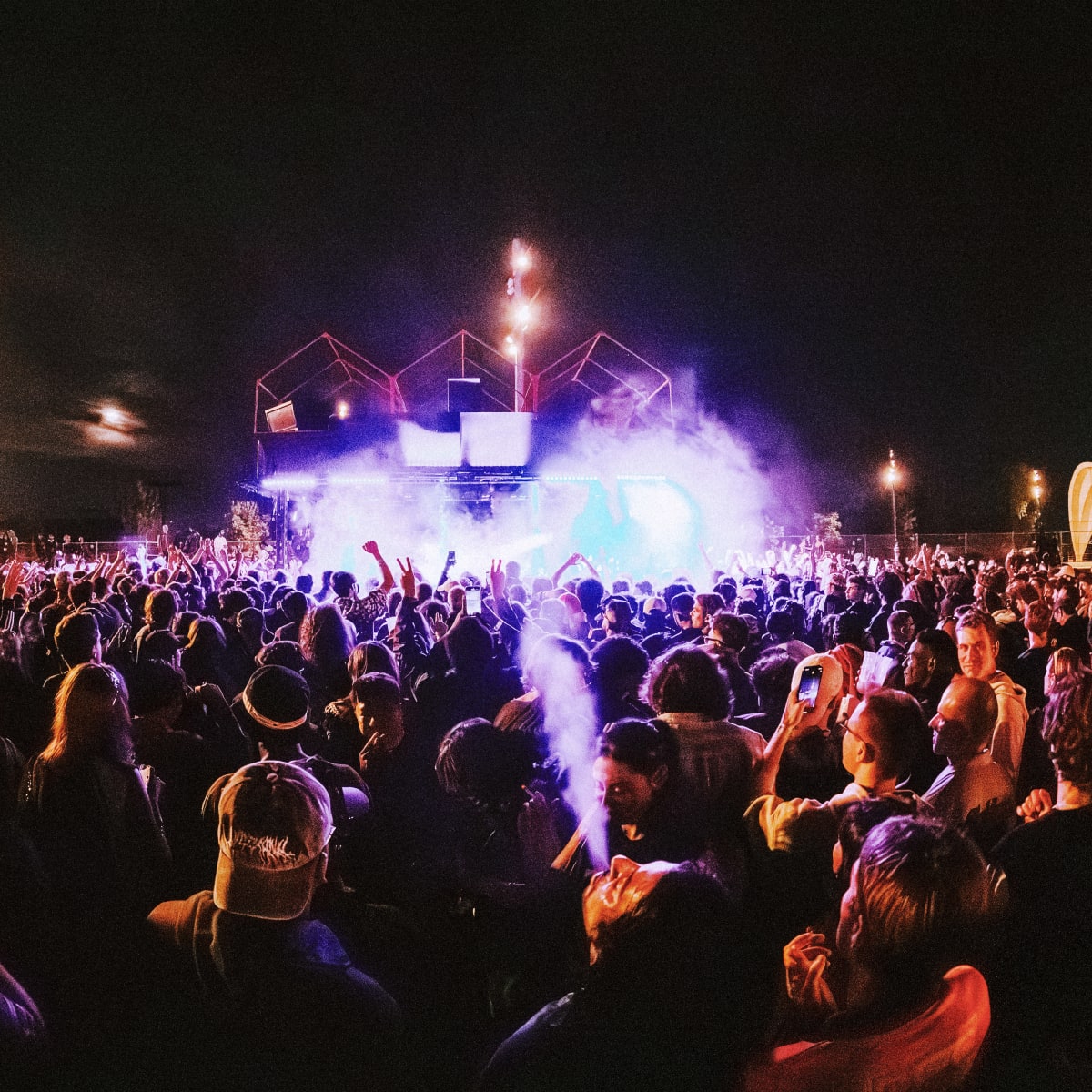 A crowd gathered in front of the stage in the evening.