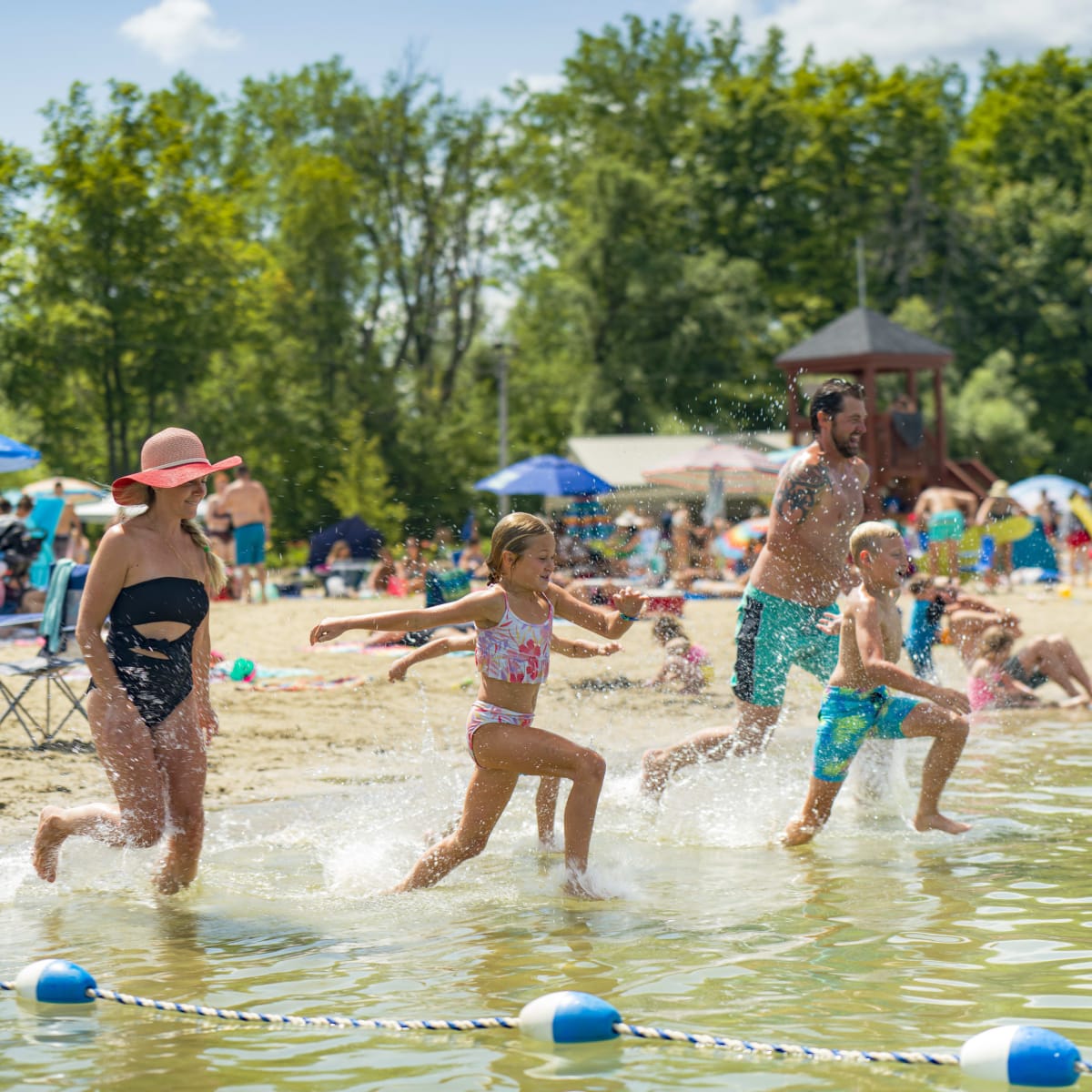 Famille courant dans l'eau à la plage.
