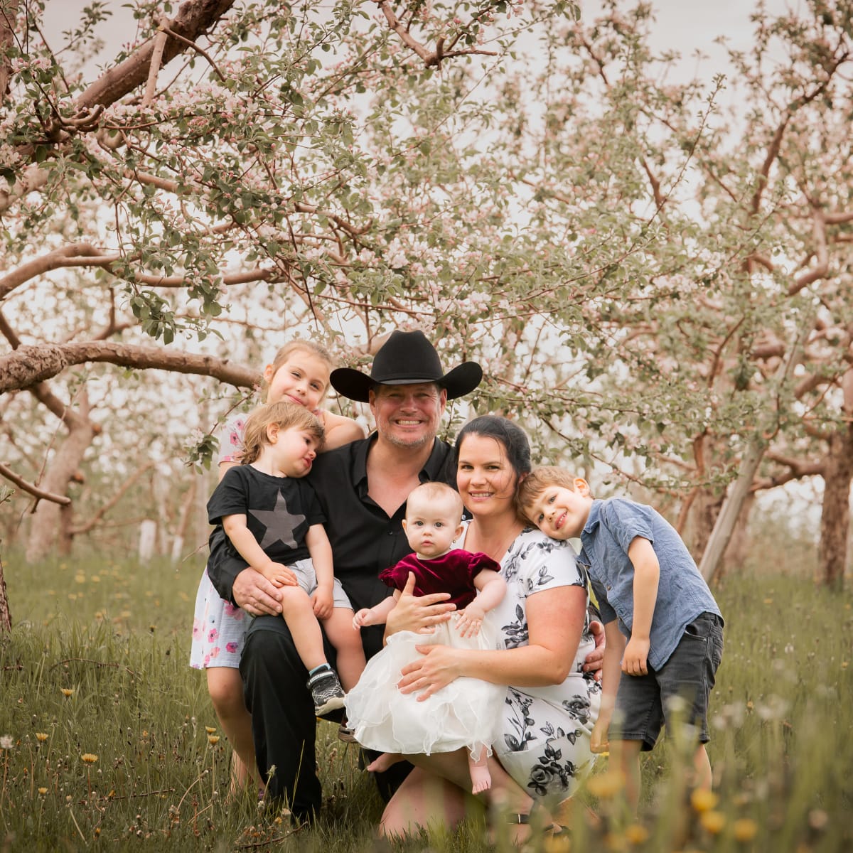 Famille du Verger du Roy entourée de pommiers en fleurs.