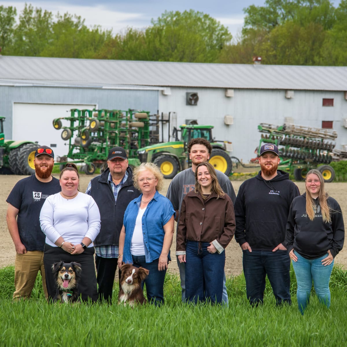 Famille de la Ferme Agrikel devant la ferme et tracteurs.