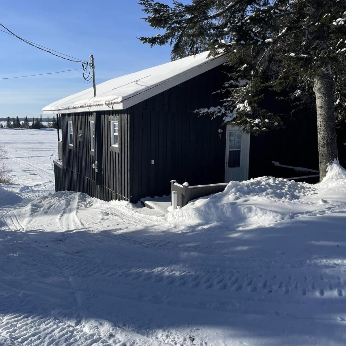 Pourvoirie Fern - Black cabin in winter