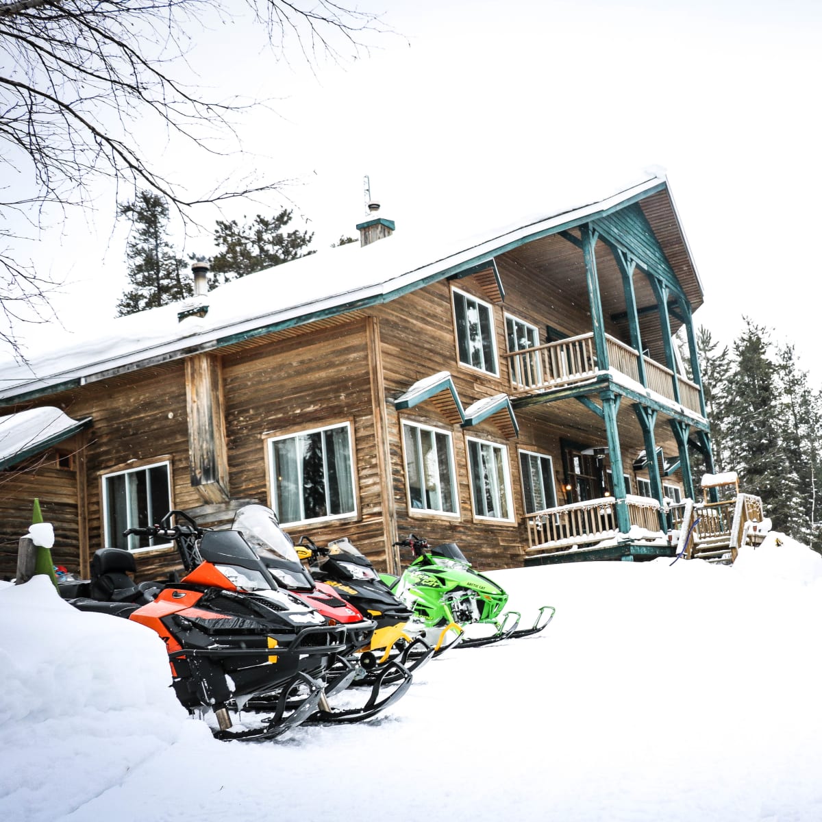 Snowmobiles next to the Pourvoirie Lac Dumoulin lodge.