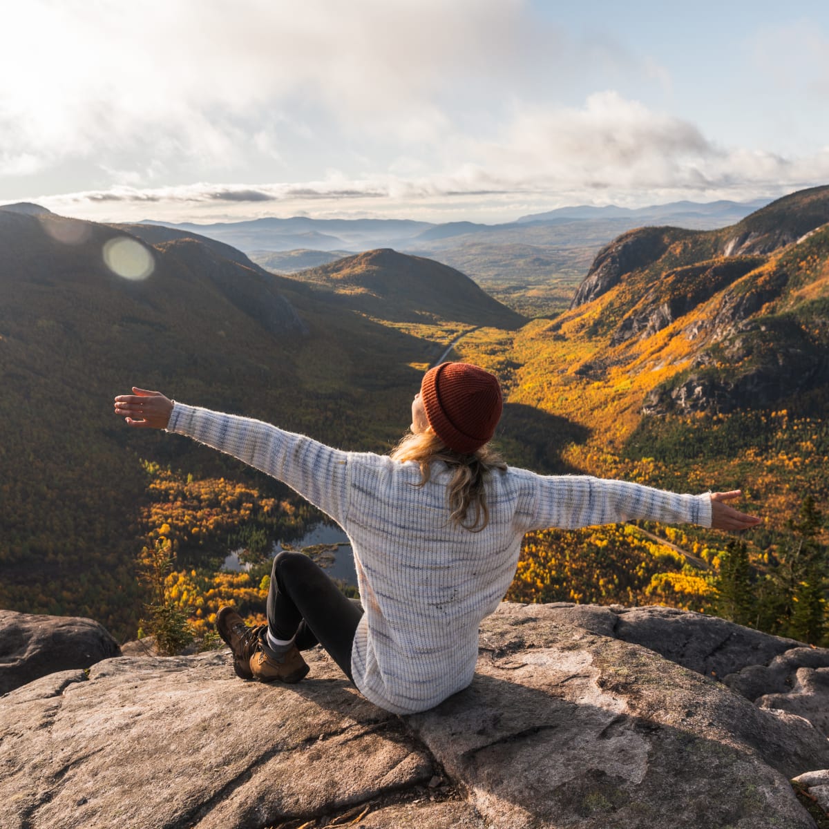 Femme en randonnée en montagne sur un sommet dans Charlevoix.