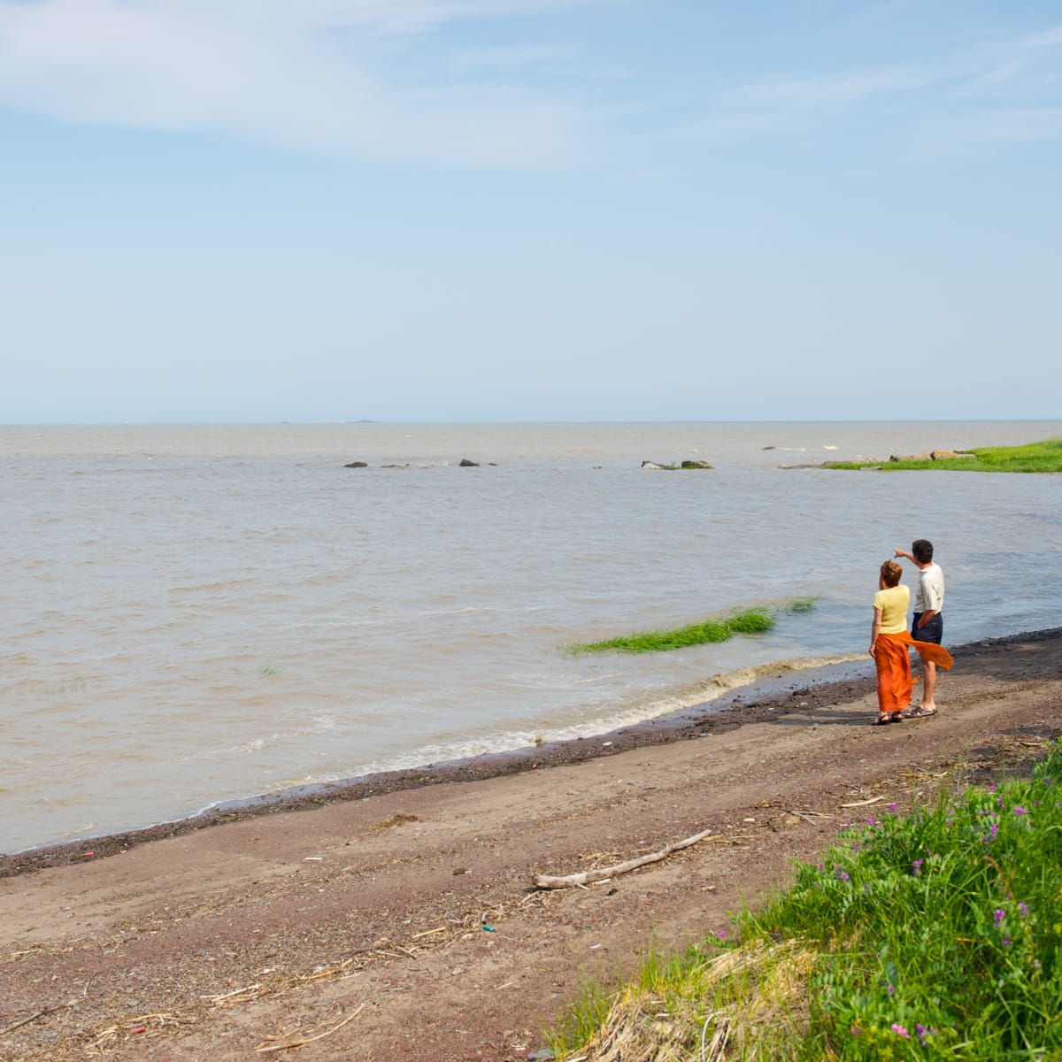 Couple by the water looking at the river.