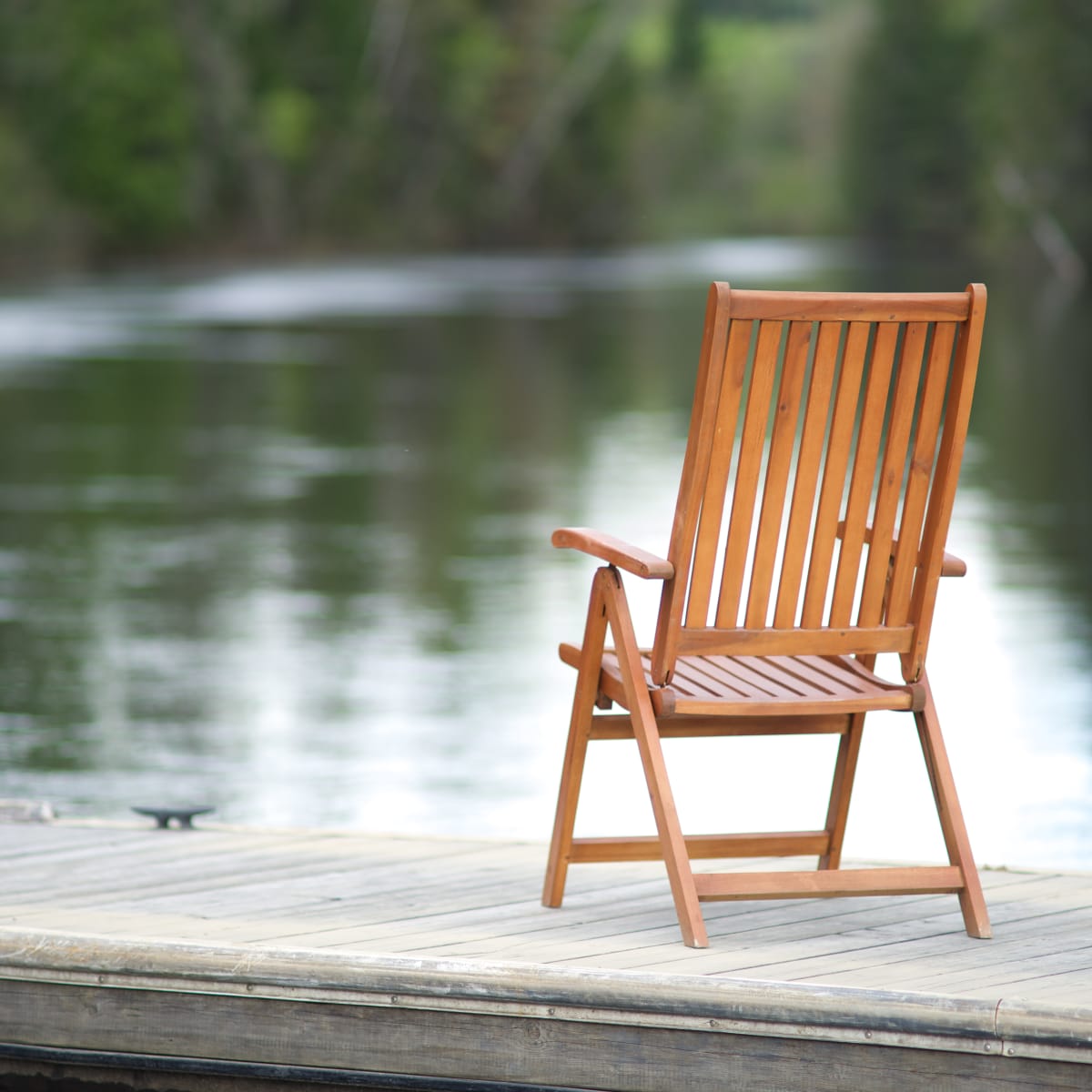 Patio chair on a deck by the water.