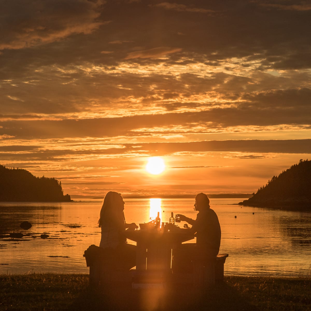 Couple having supper by the water.