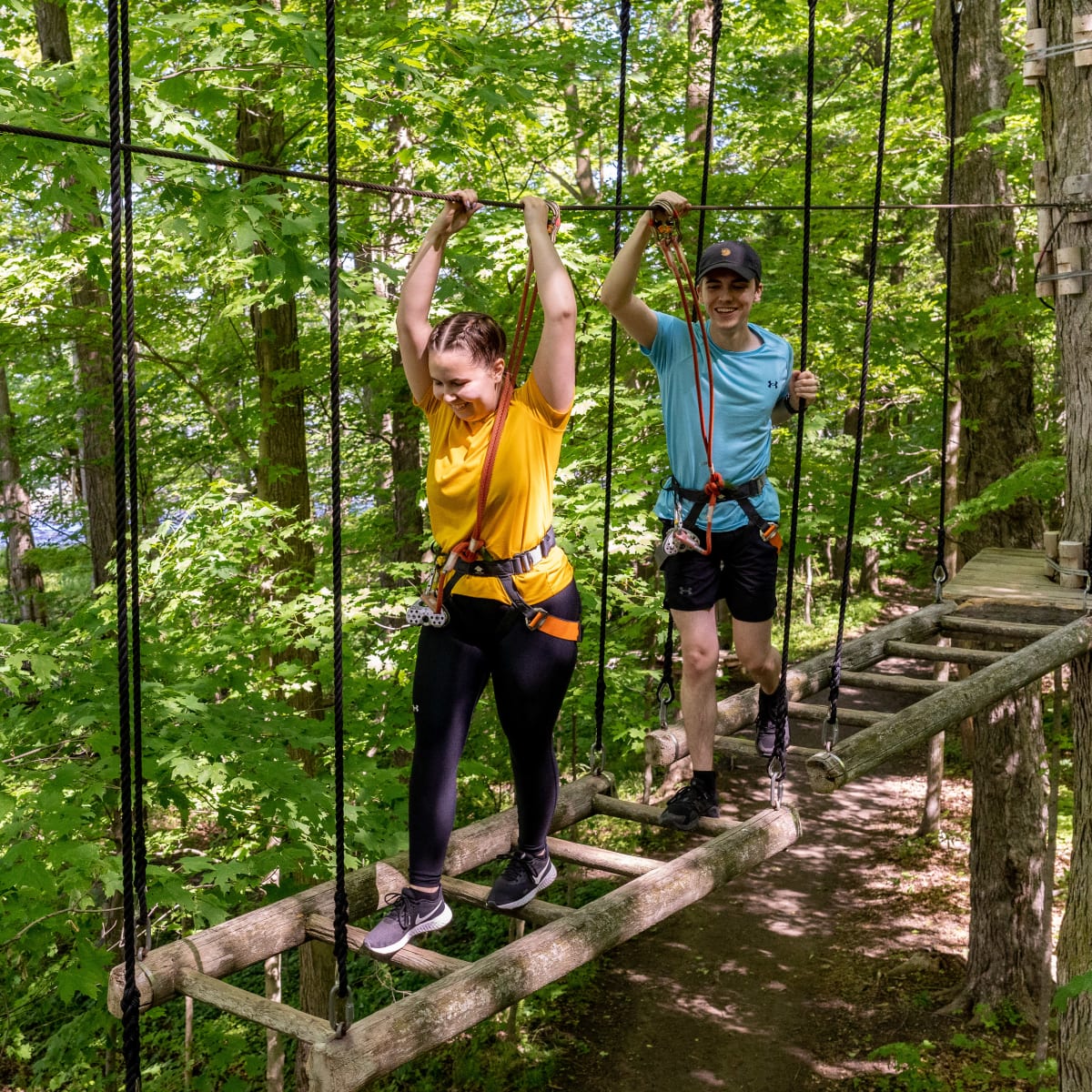 Two teenagers in a forest adventure park.