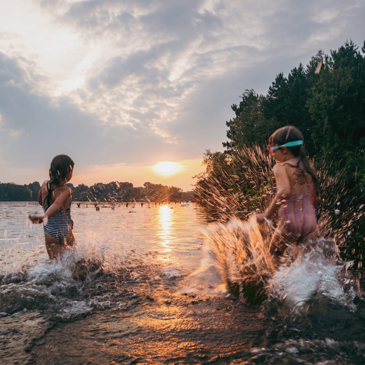 Jeunes enfants dans l'eau au coucher du soleil