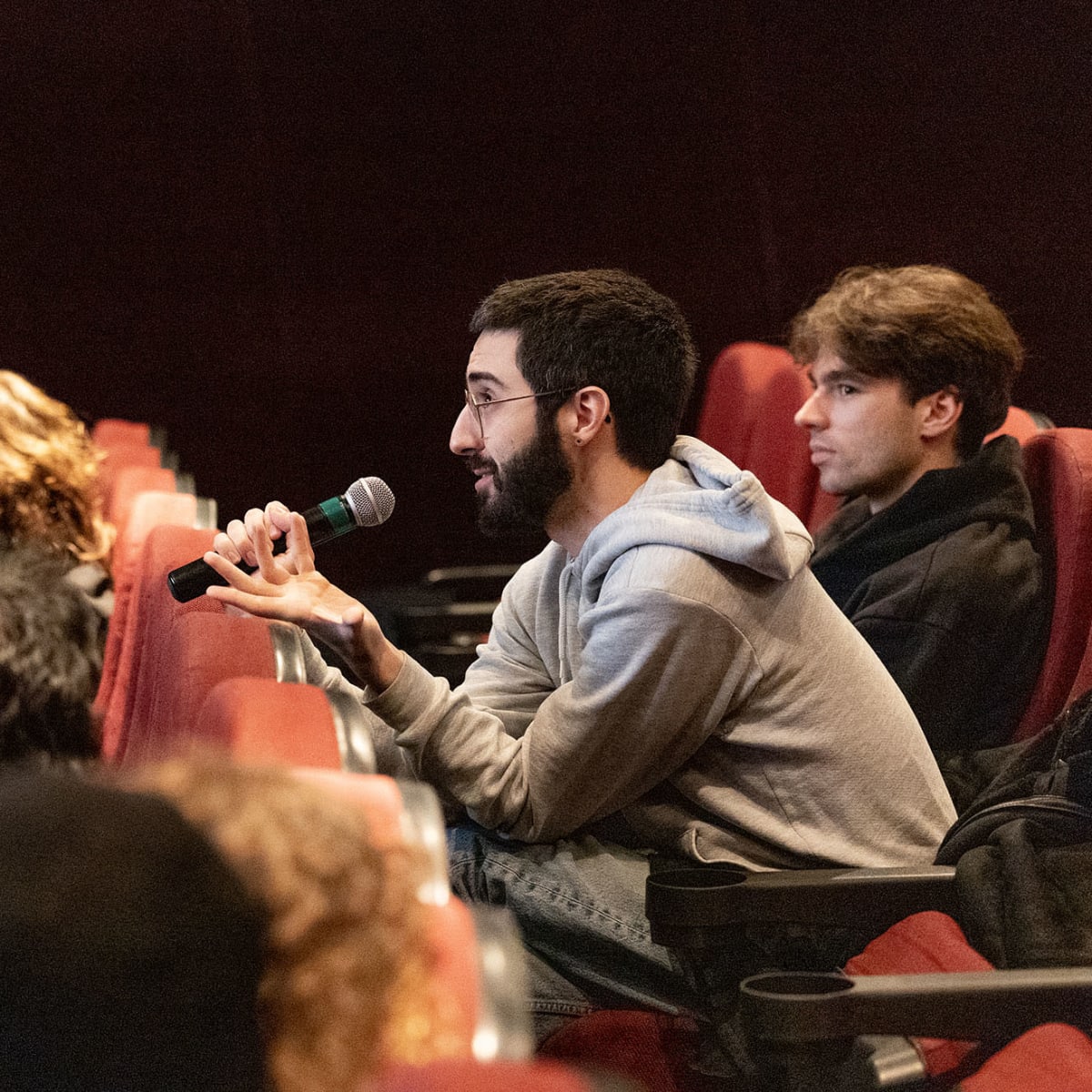 An individual holding a microphone at the event Rencontres Internationales du documentaire de Montréal (RIDM).