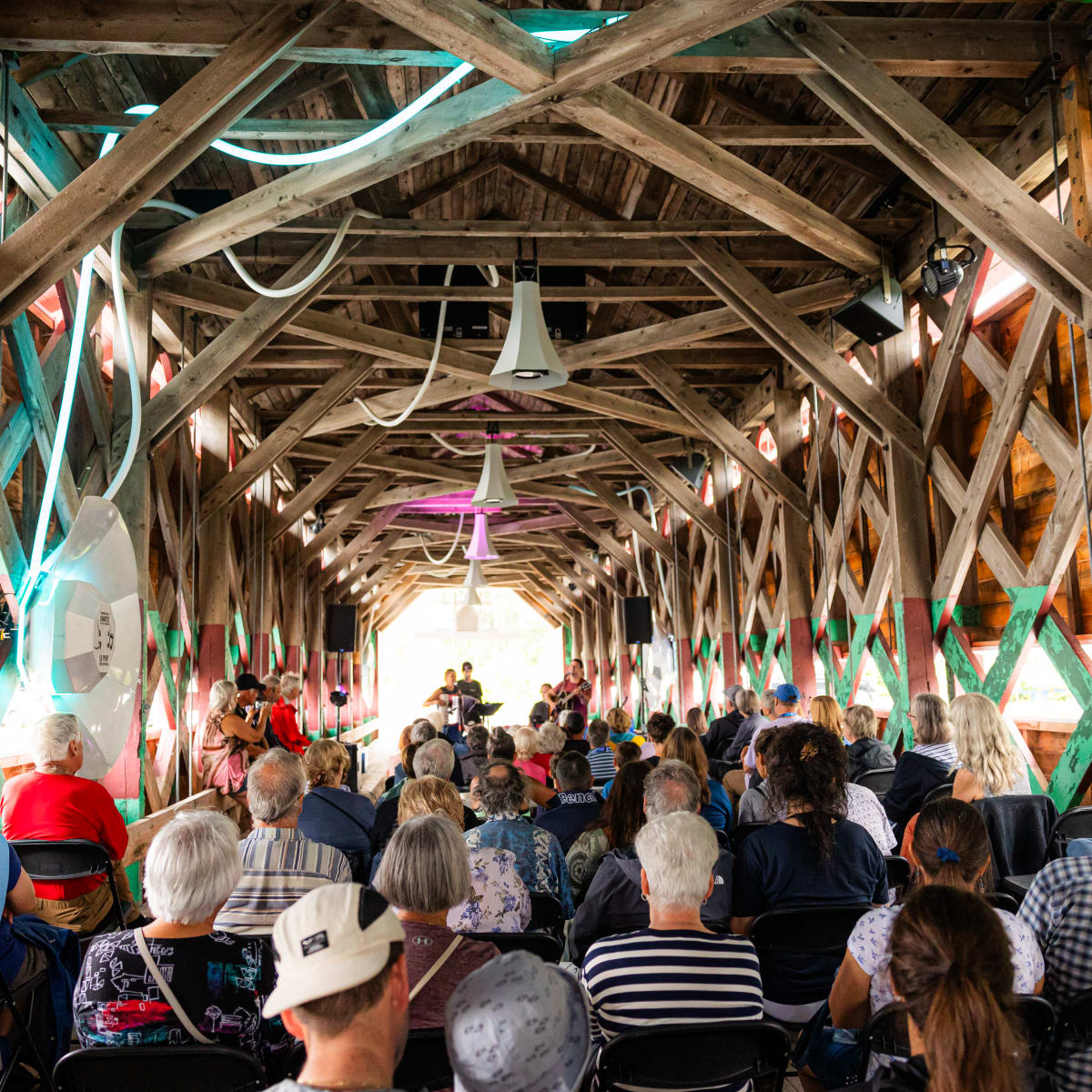 Audience seated in a barn converted into a performance venue.