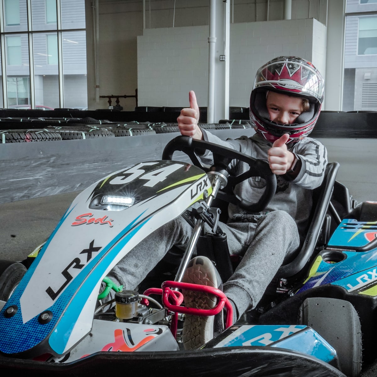 Young boy in a kart on a karting track.