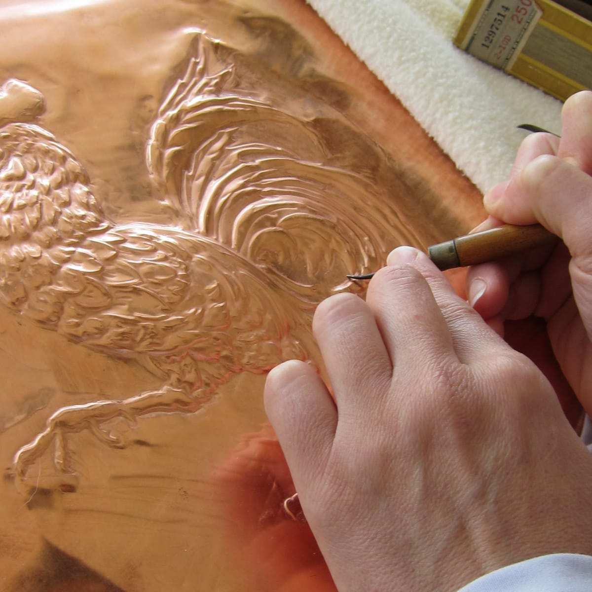 Artist embossing a sheet of copper