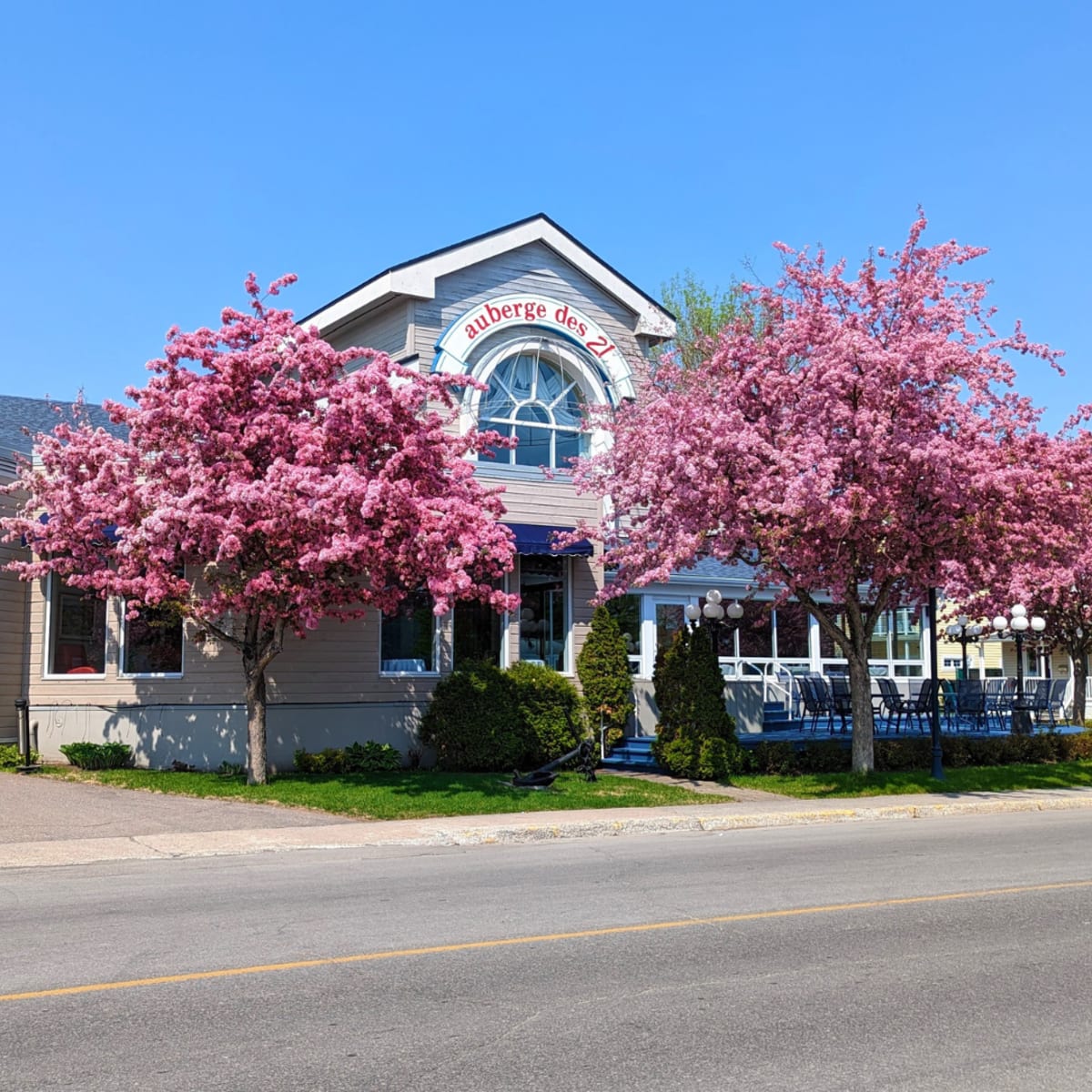 The front view of the Auberge des 21 hotel in the spring.