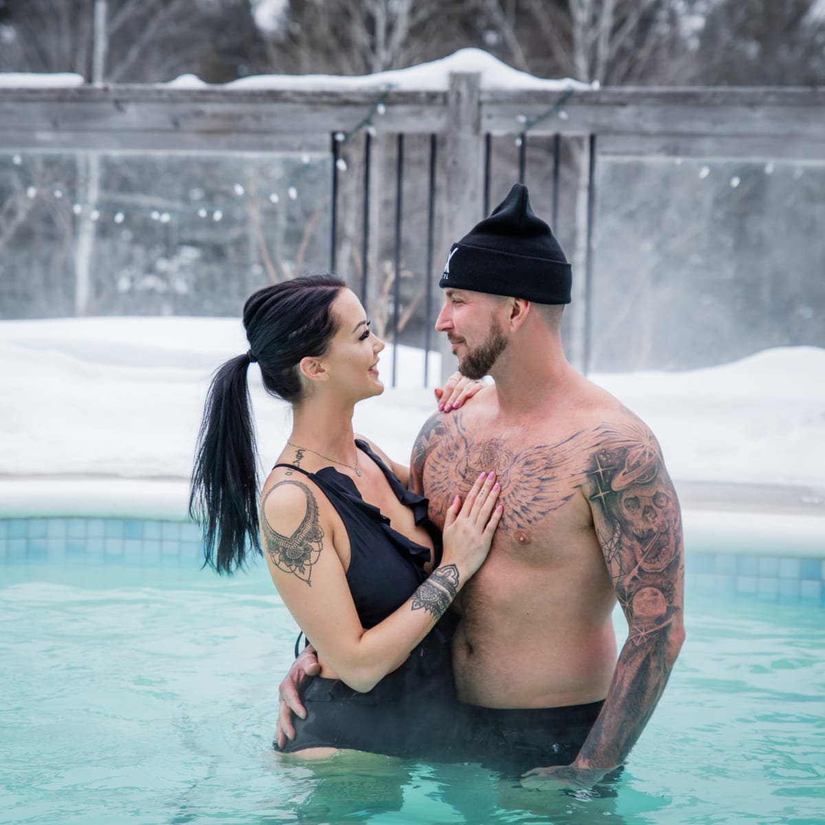 Young couple in bathing suits in the outdoor pool in winter at the AX Hotel in Tremblant.