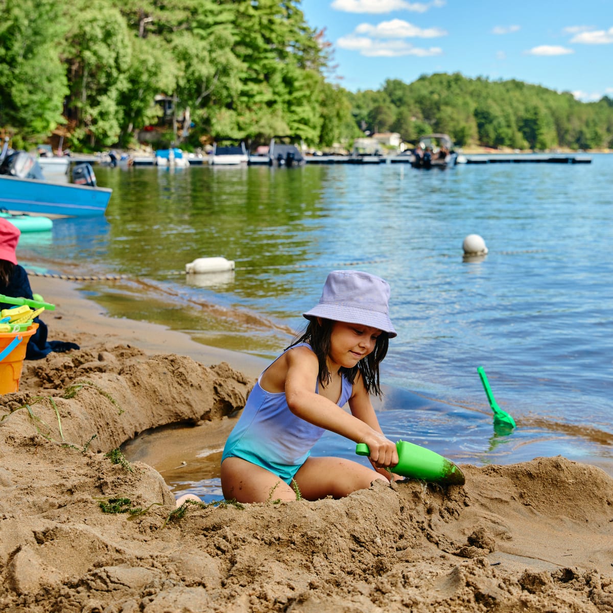 Little girl building a sand castle on the beach.