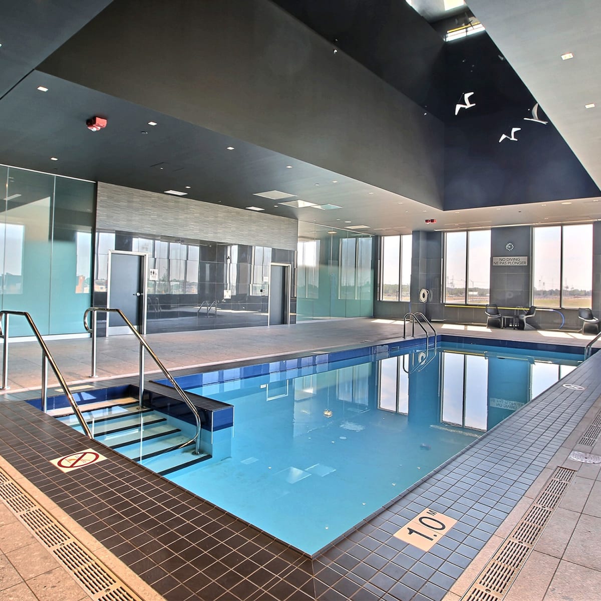 Piscine intérieure de l'hôtel dans une salle vitrée.
