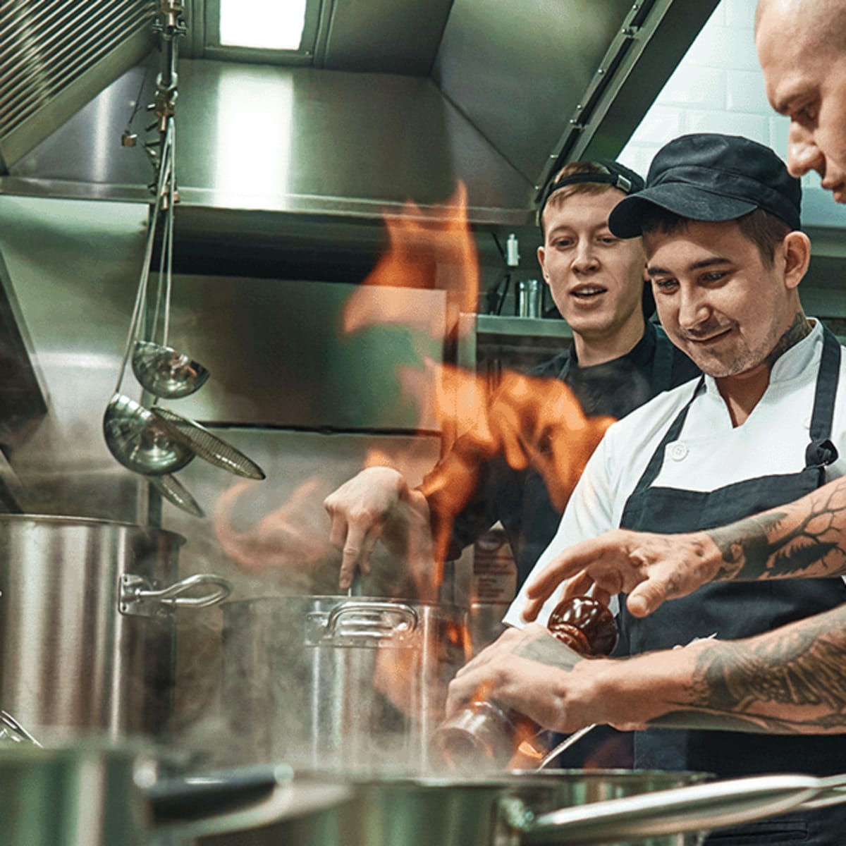 Three men working in an industrial kitchen.