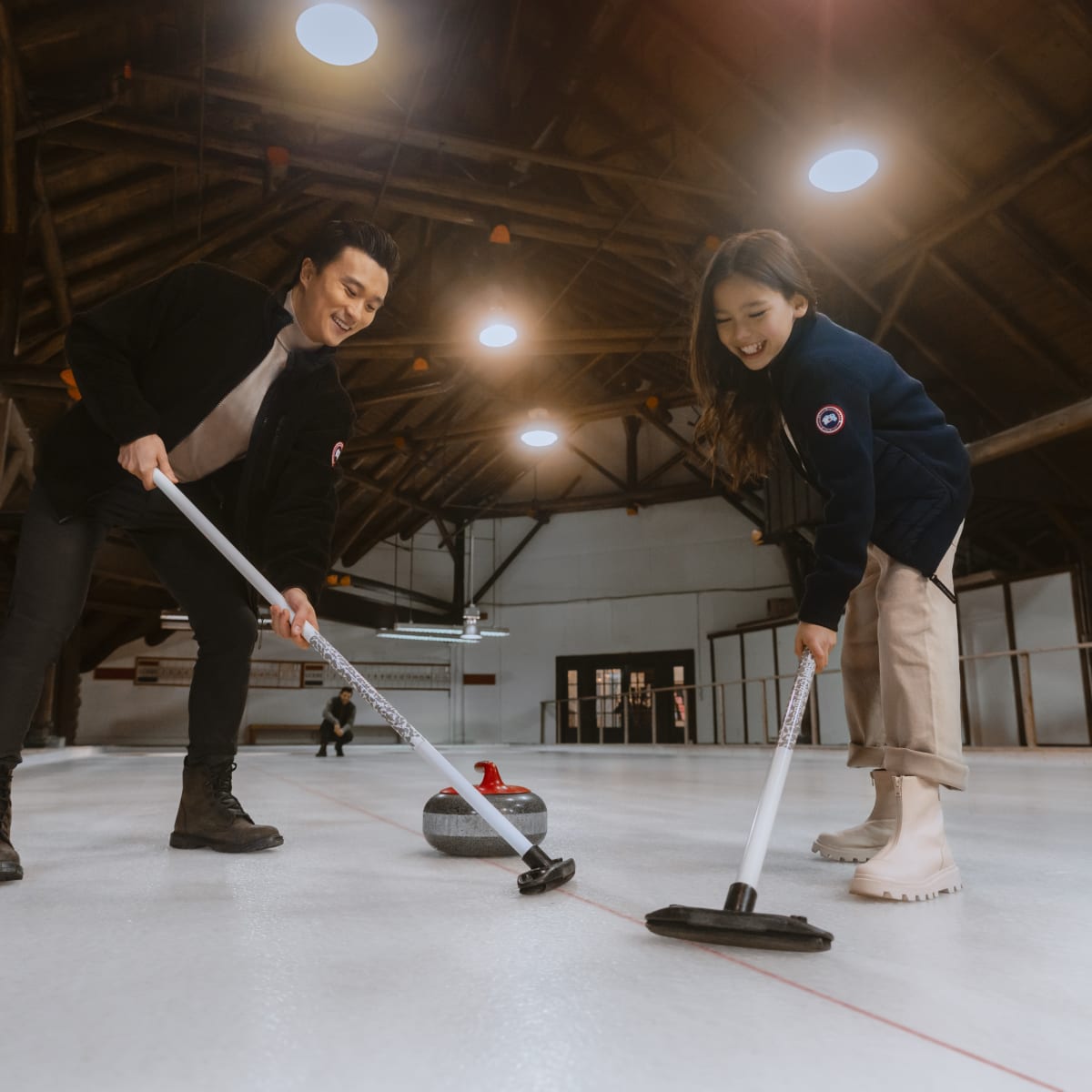 Two people playing curling.