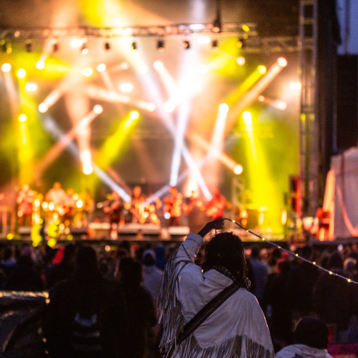 Scène illuminée avec spectacle en fin de soirée pendant le festival Innu Nikamu.