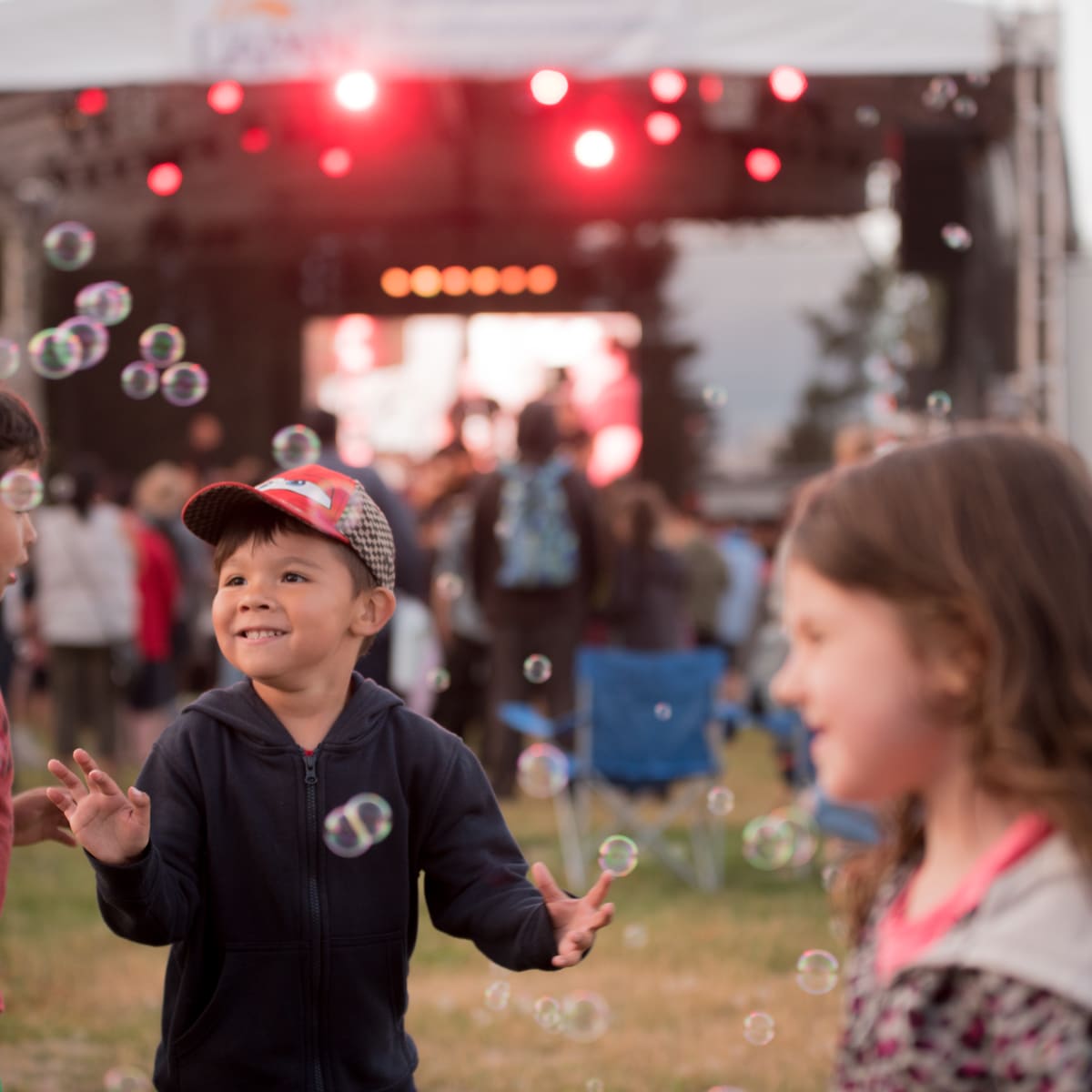 3 enfants qui s'amusent devant la scène au festival.