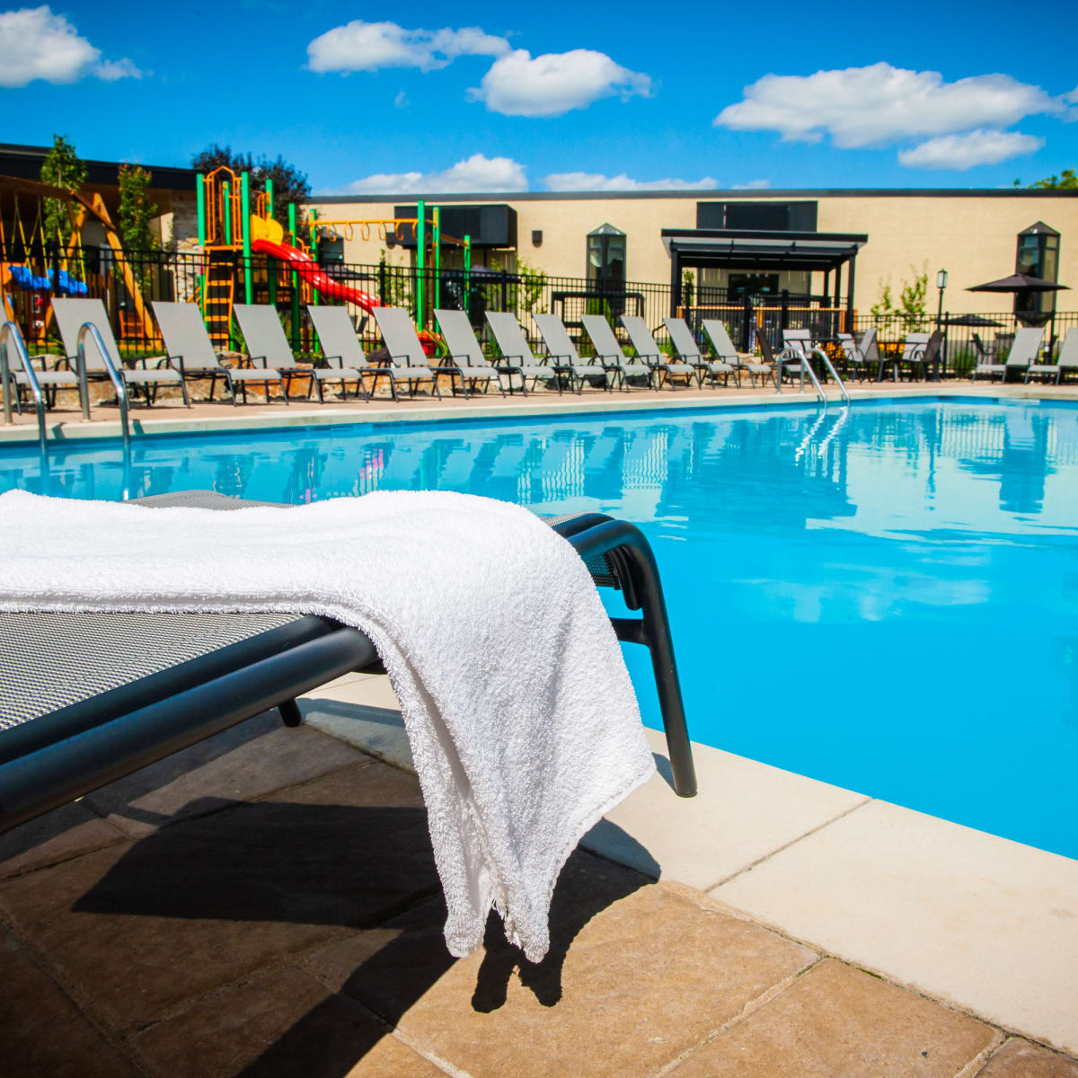 Outdoor pool surrounded by patio chairs at Hôtel Castel.