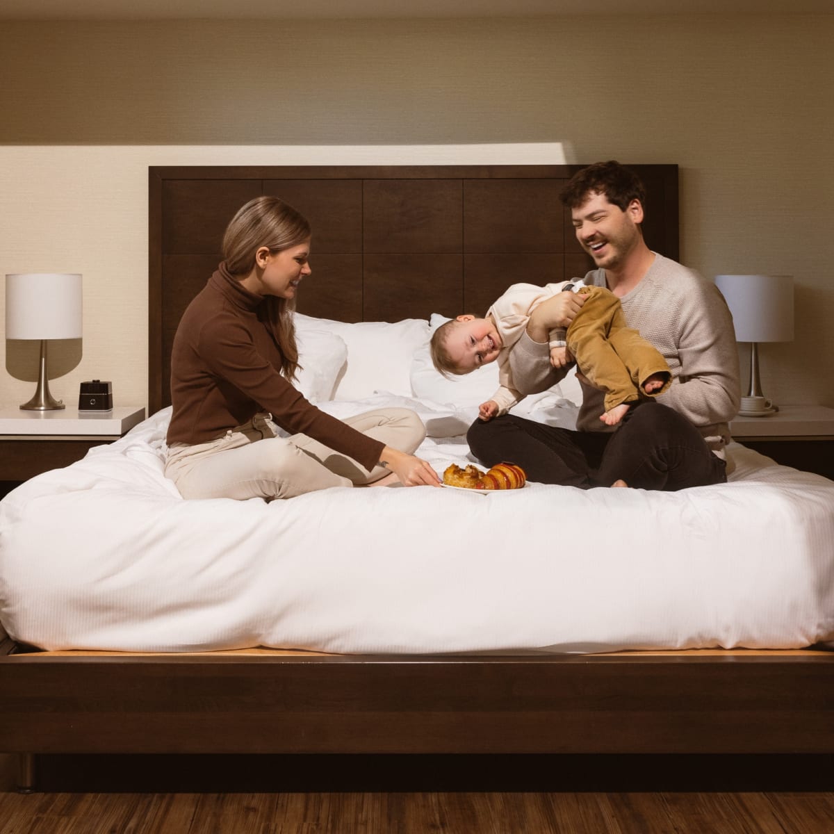 Deux jeunes parents et un enfant sur un lit.