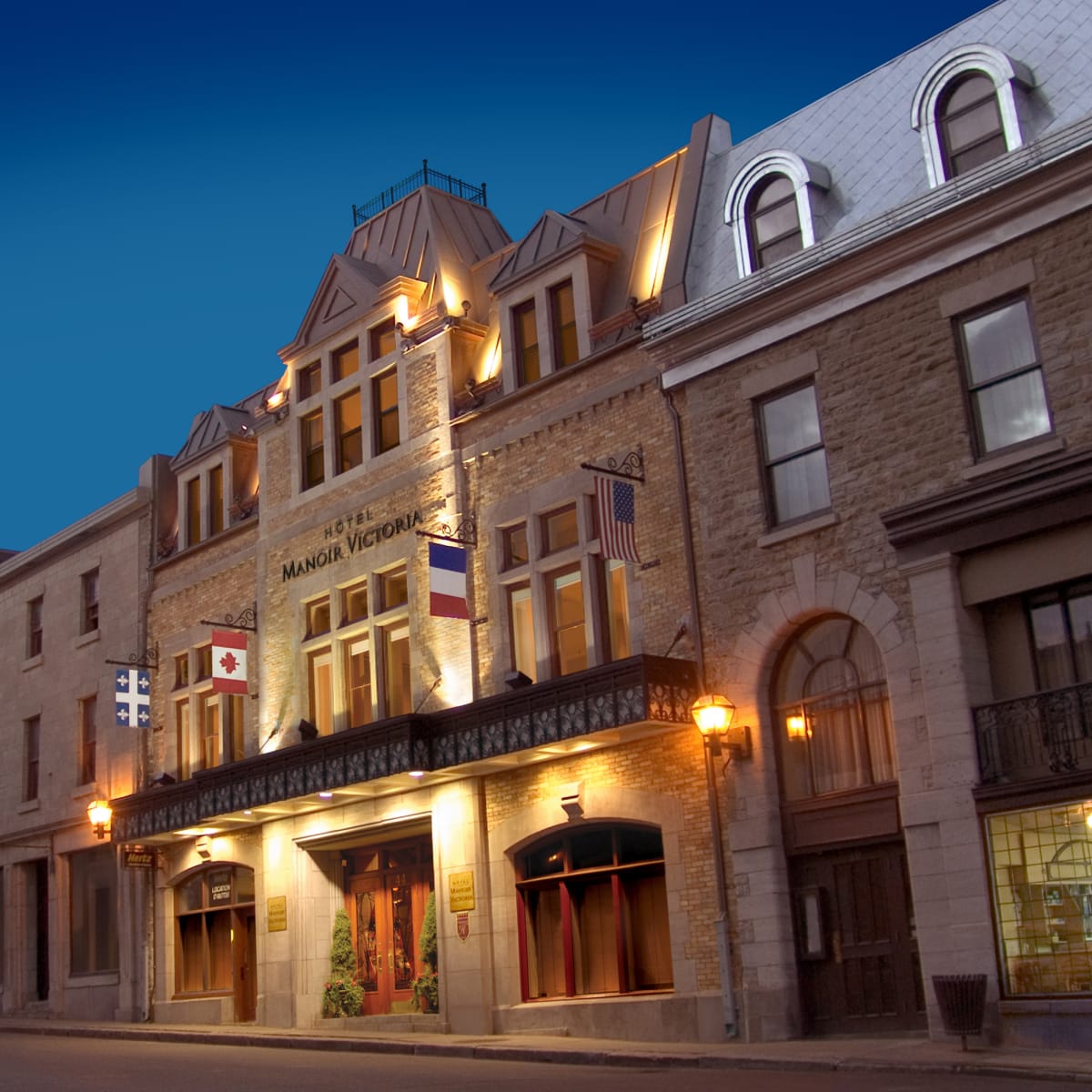 Façade de l'Hôtel Manoir Victoria en début de soirée.