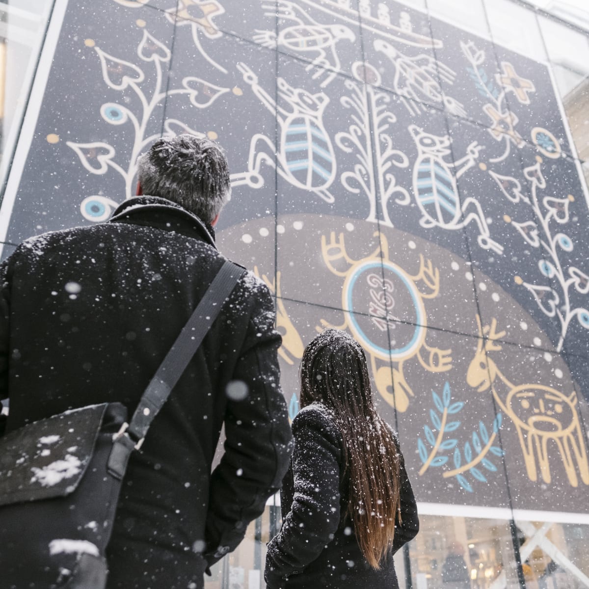 A man and a woman looking at a mural