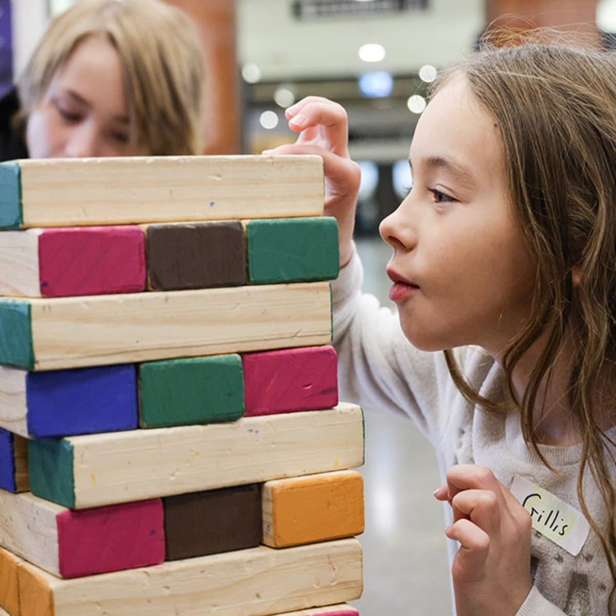 Deux enfants qui jouent à un jeu de jenga au musée.