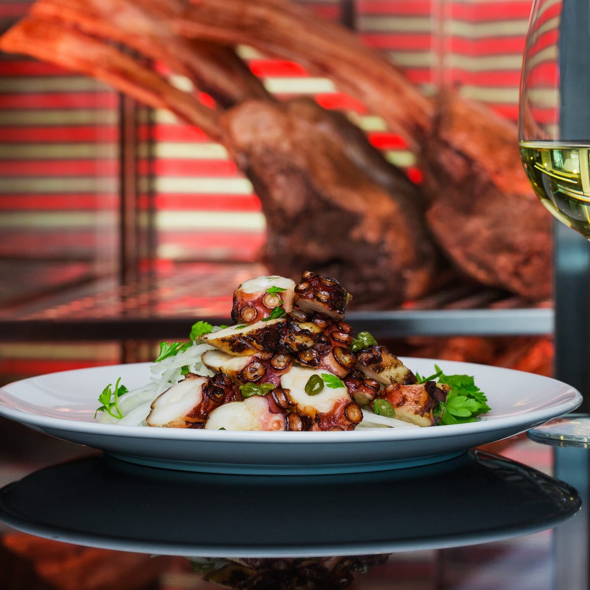 Assiette de fruits de mer soigneusement apprêtés, servie avec un verre de vin blanc.