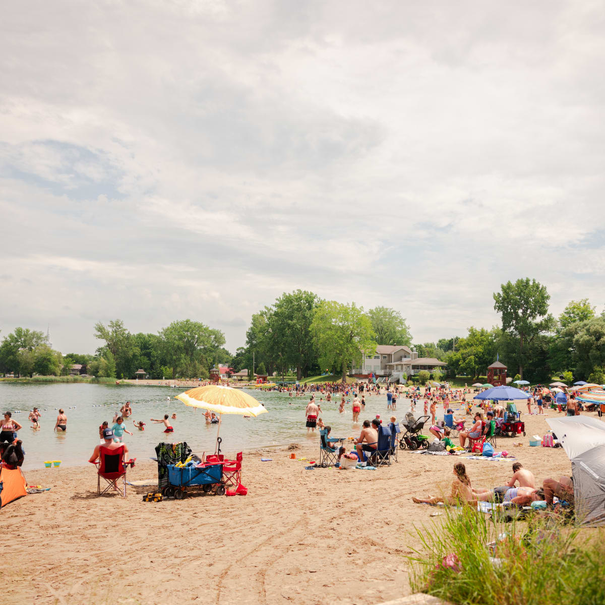 A golden-sand beach with dozens of beach-goers.
