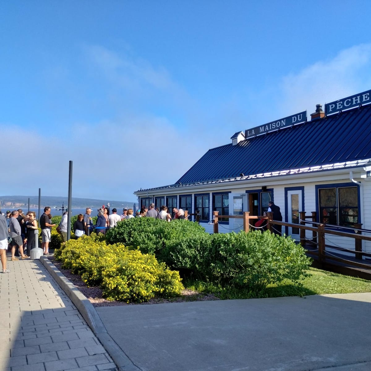 File d’attente à l’extérieur d’un restaurant appelé La Maison du Pêcheur.