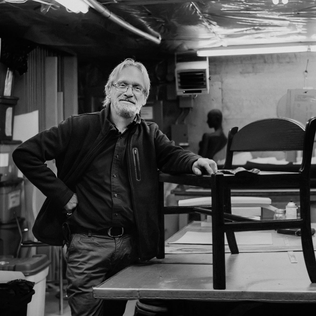 Woodwroking artisan displaying a chair on a workbench.
