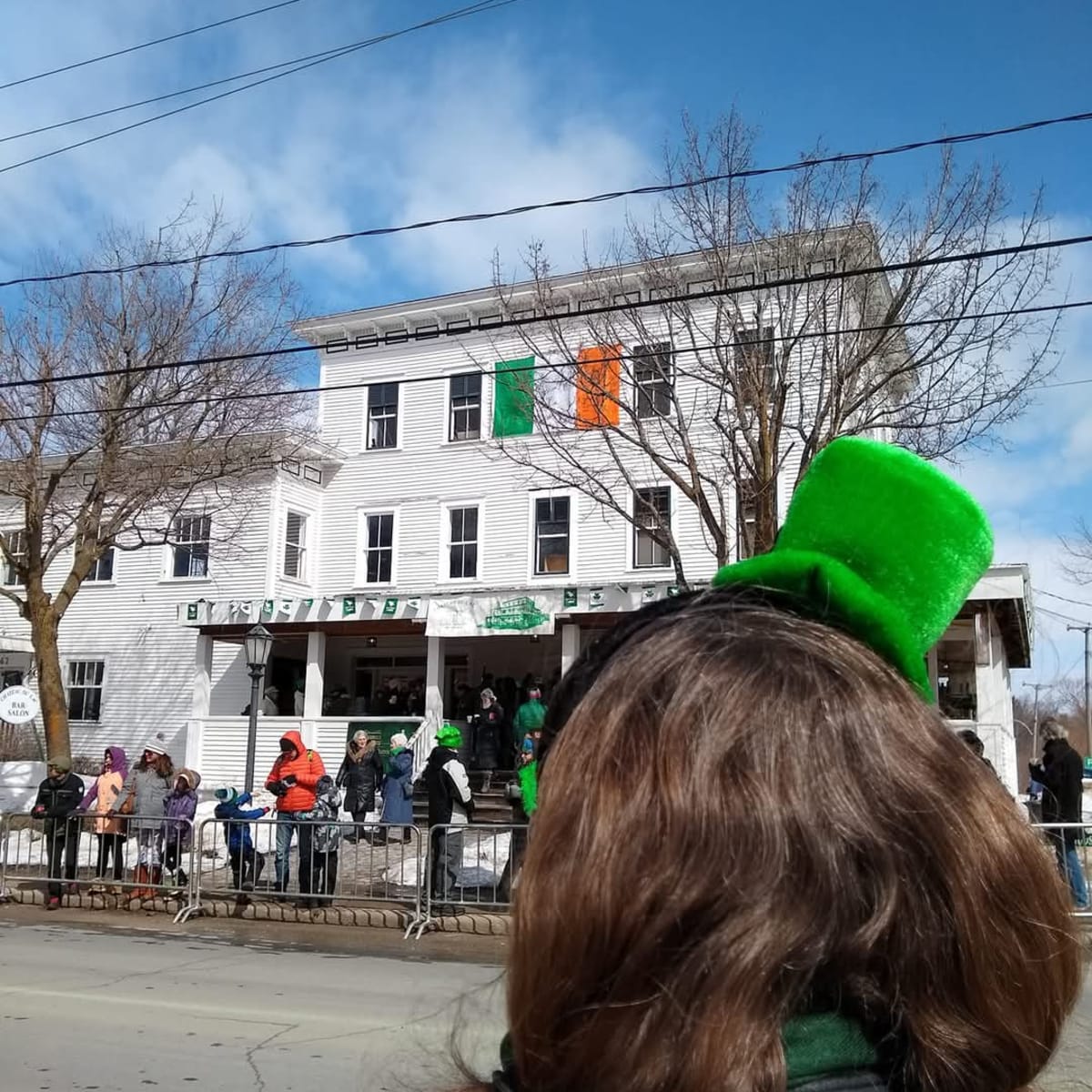 Young woman wearing a St Patrick's Day hat waiting for the parade to strart.