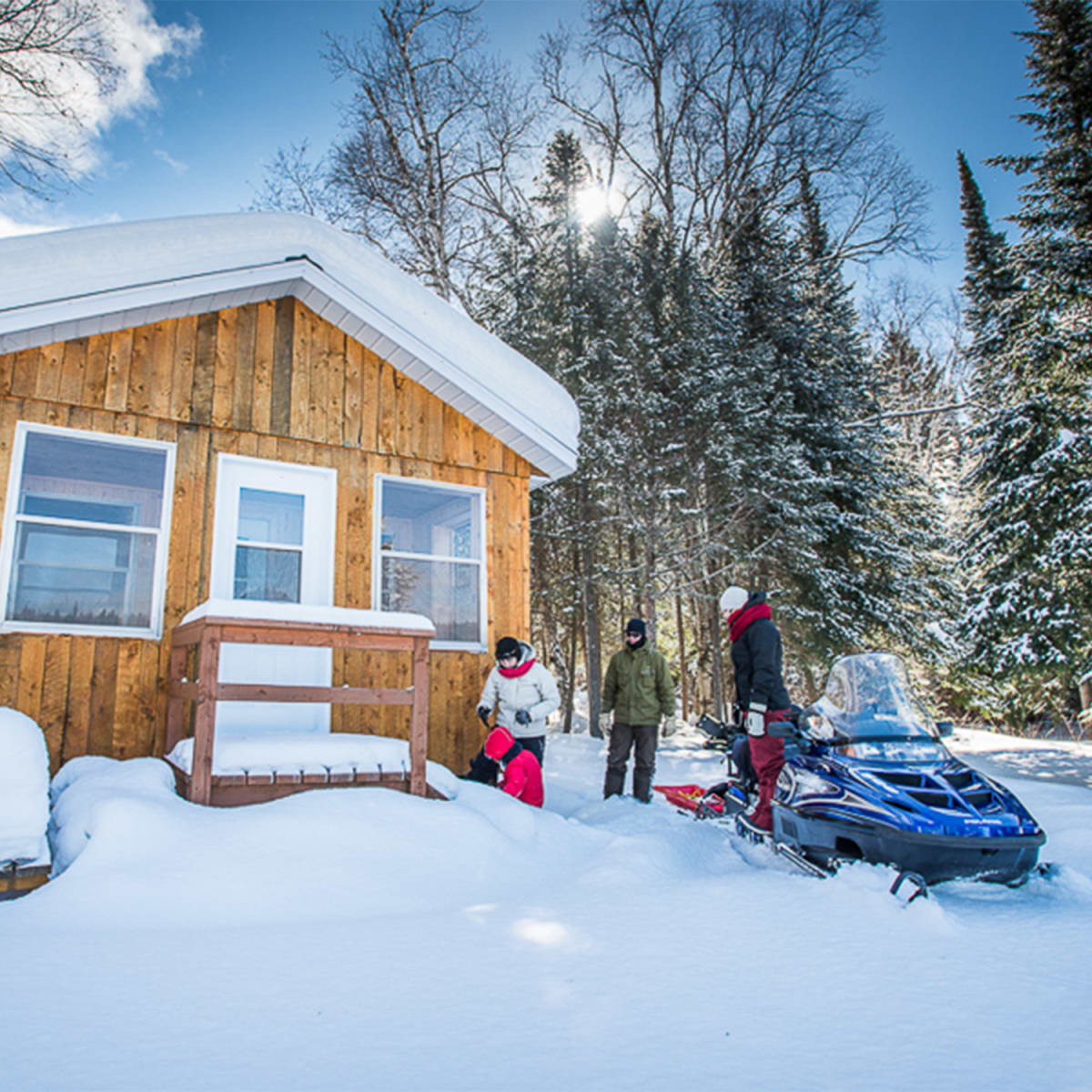 Chalet in winter with snowmobiler