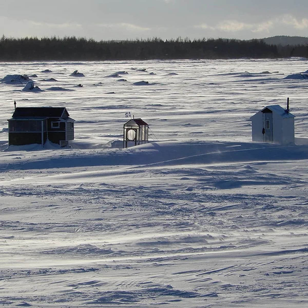 Ice fishing cabins on a frozen lake