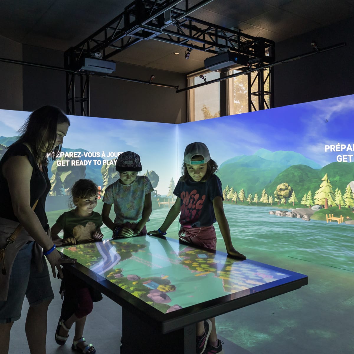 4 kids around an interactive display at the Acoatica exhibit.