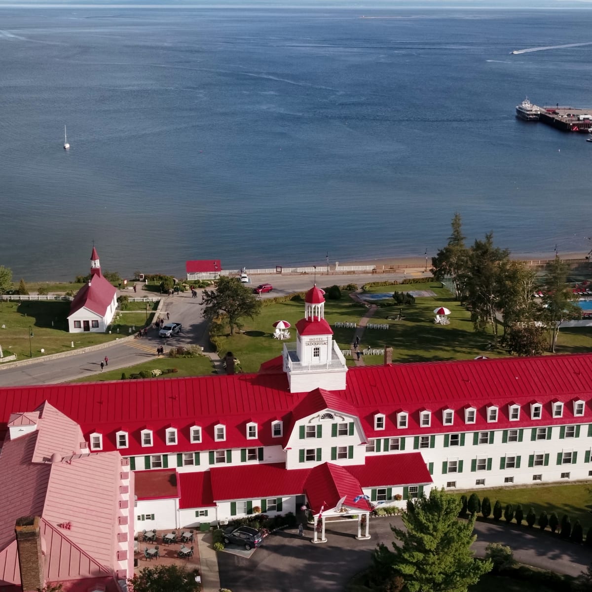 Vue aérienne d'un hôtel au toit rouge situé au bord de l'eau.