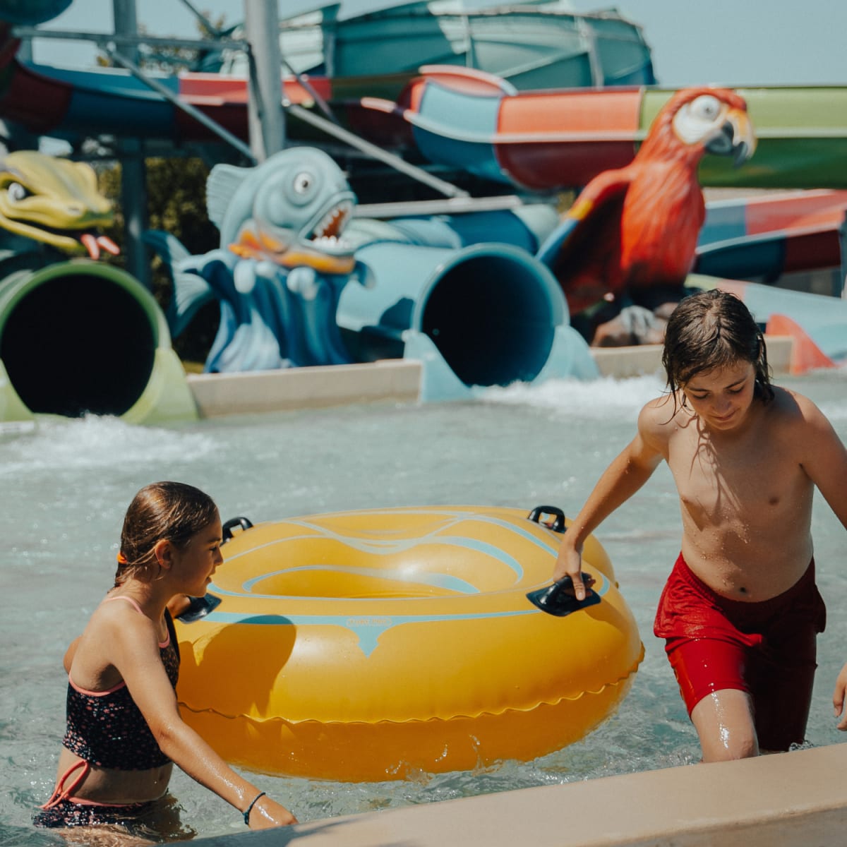 Young girl and boy with an inflatable tube in a pool.