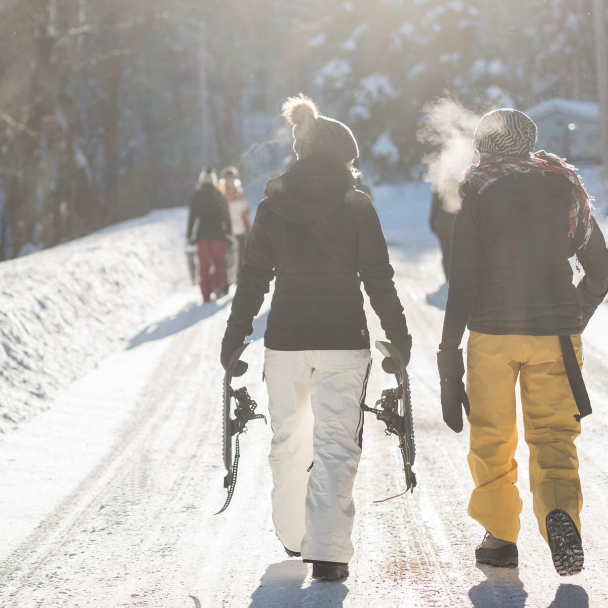 Couple en habits de neige sur un sentier de raquette.