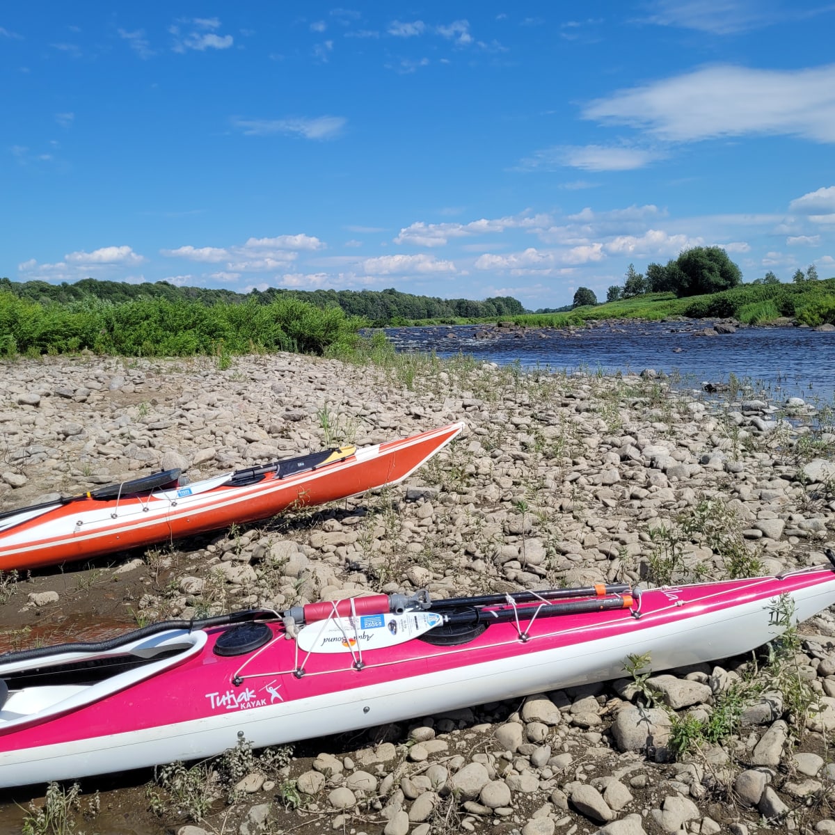 Deux kayaks sur la rive d’un cours d’eau.